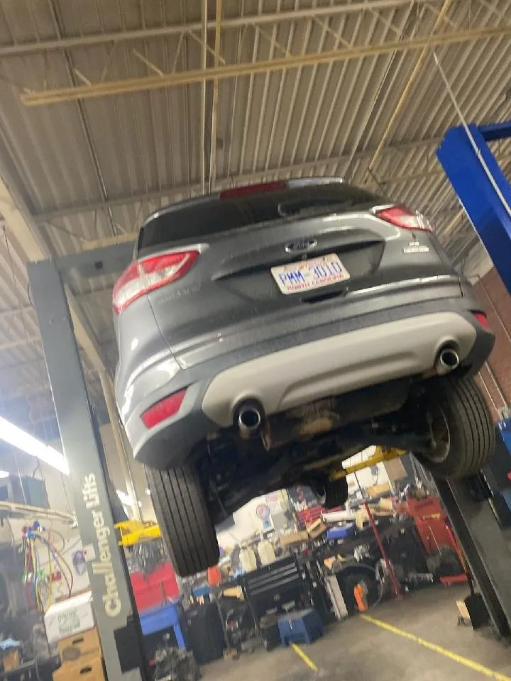 A crossover SUV raised on a lift at Transpecialists with its transmission removed.