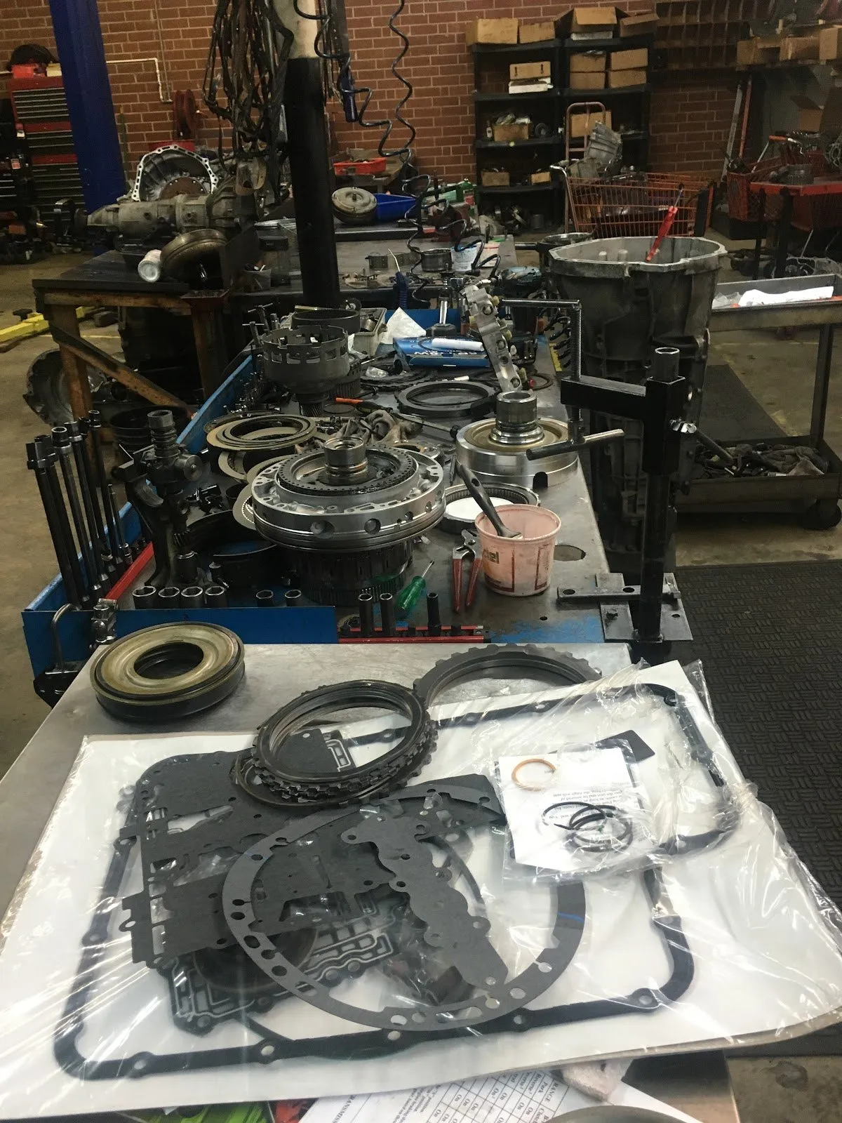 A transmission rebuild in progress — valve body, gaskets and new seals laid out on the bench.